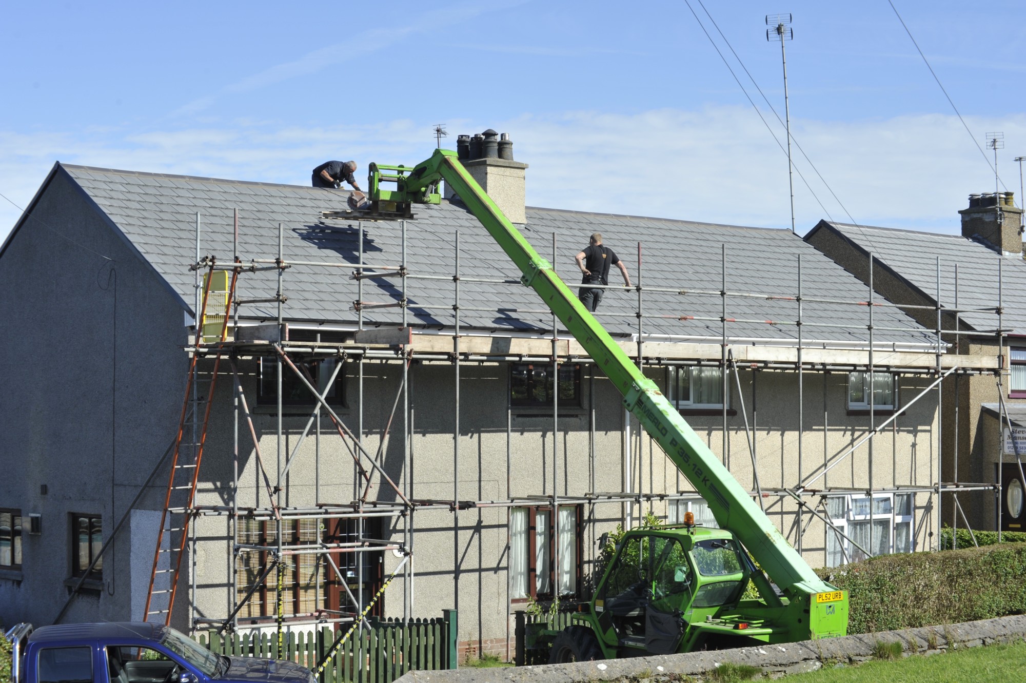 People Fixing a Roof Using a Scaffolding